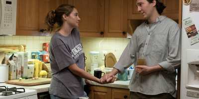 Paul Dano as Brockton's Keith Gill, right, and Shailene Woodley as Caroline Gill, wearing a Stonehill College T-shirt, appear in a scene from "Dumb Money." (Claire Folger/Sony Pictures via AP)